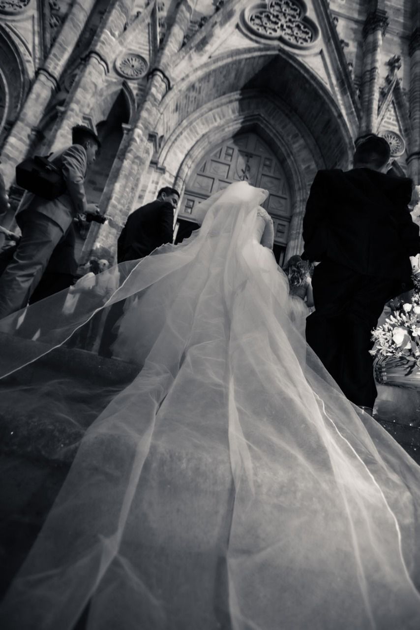 Una novia y un novio caminan por el pasillo de una iglesia.