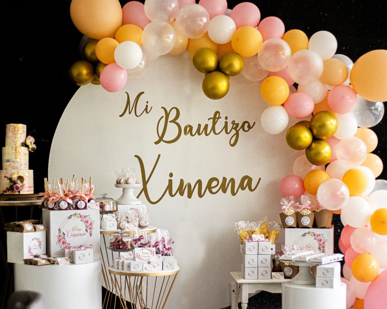 Una mesa con globos y un cartel que dice mi bautizo ximena