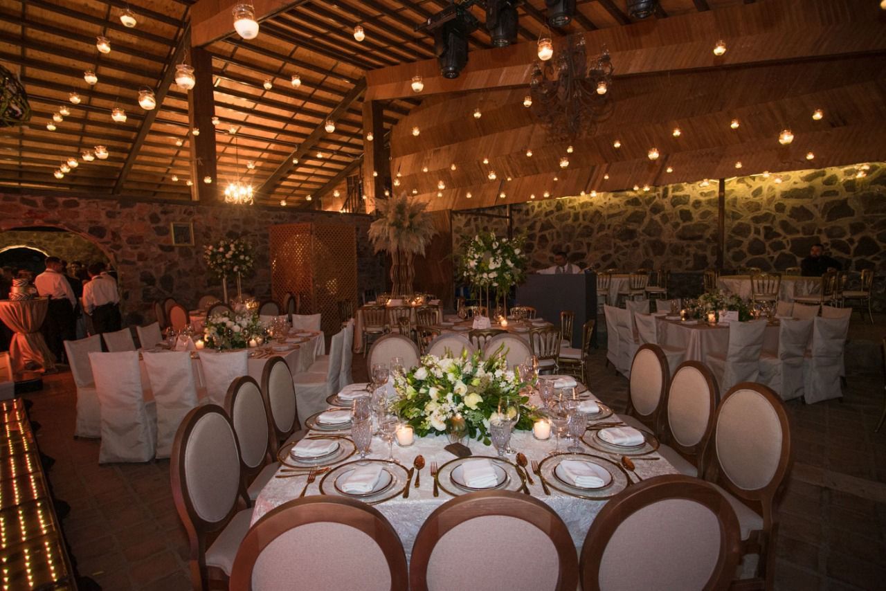 Una gran sala con mesas y sillas preparadas para una recepción de boda.