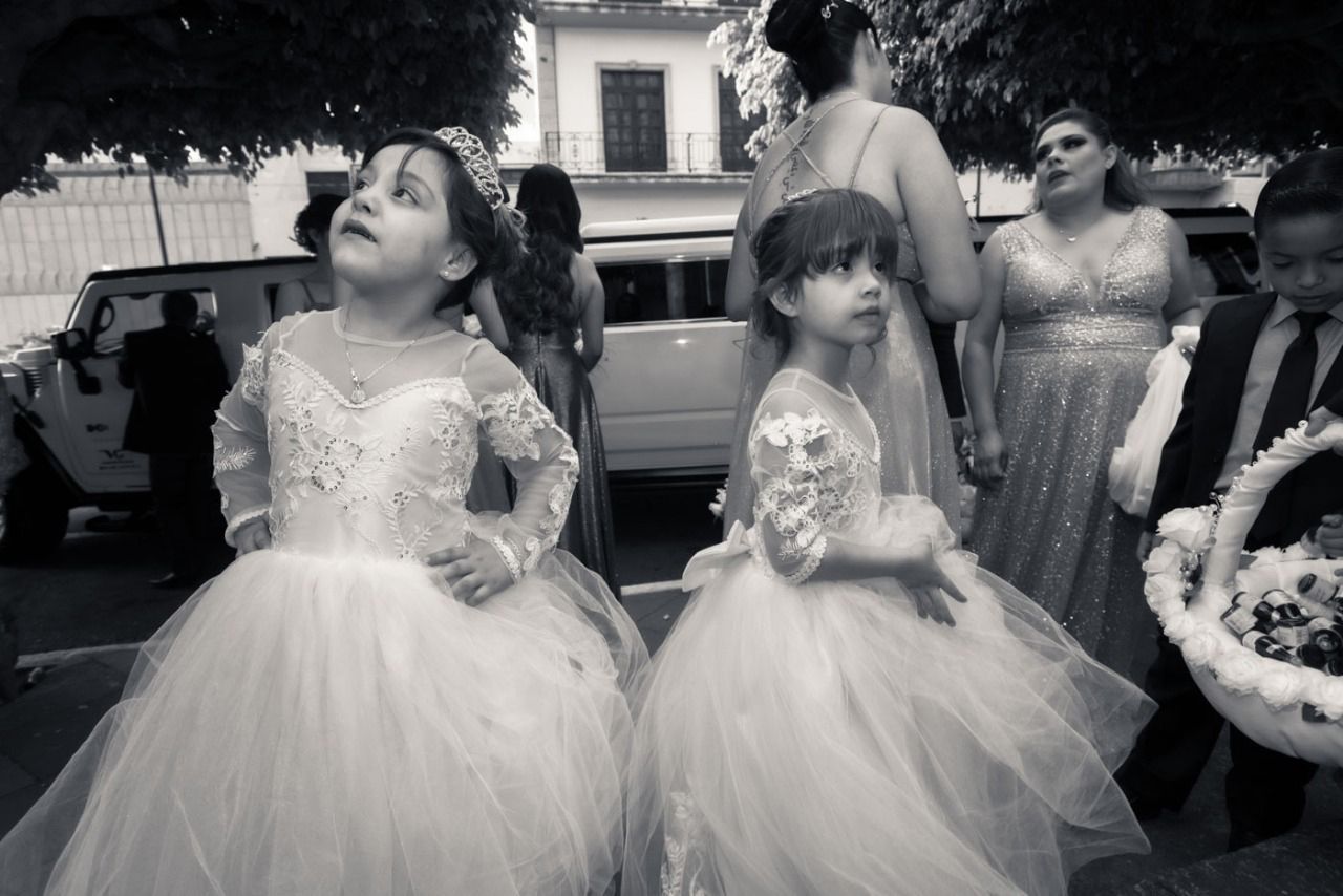 Dos niñas de las flores están paradas una al lado de la otra en una foto en blanco y negro.
