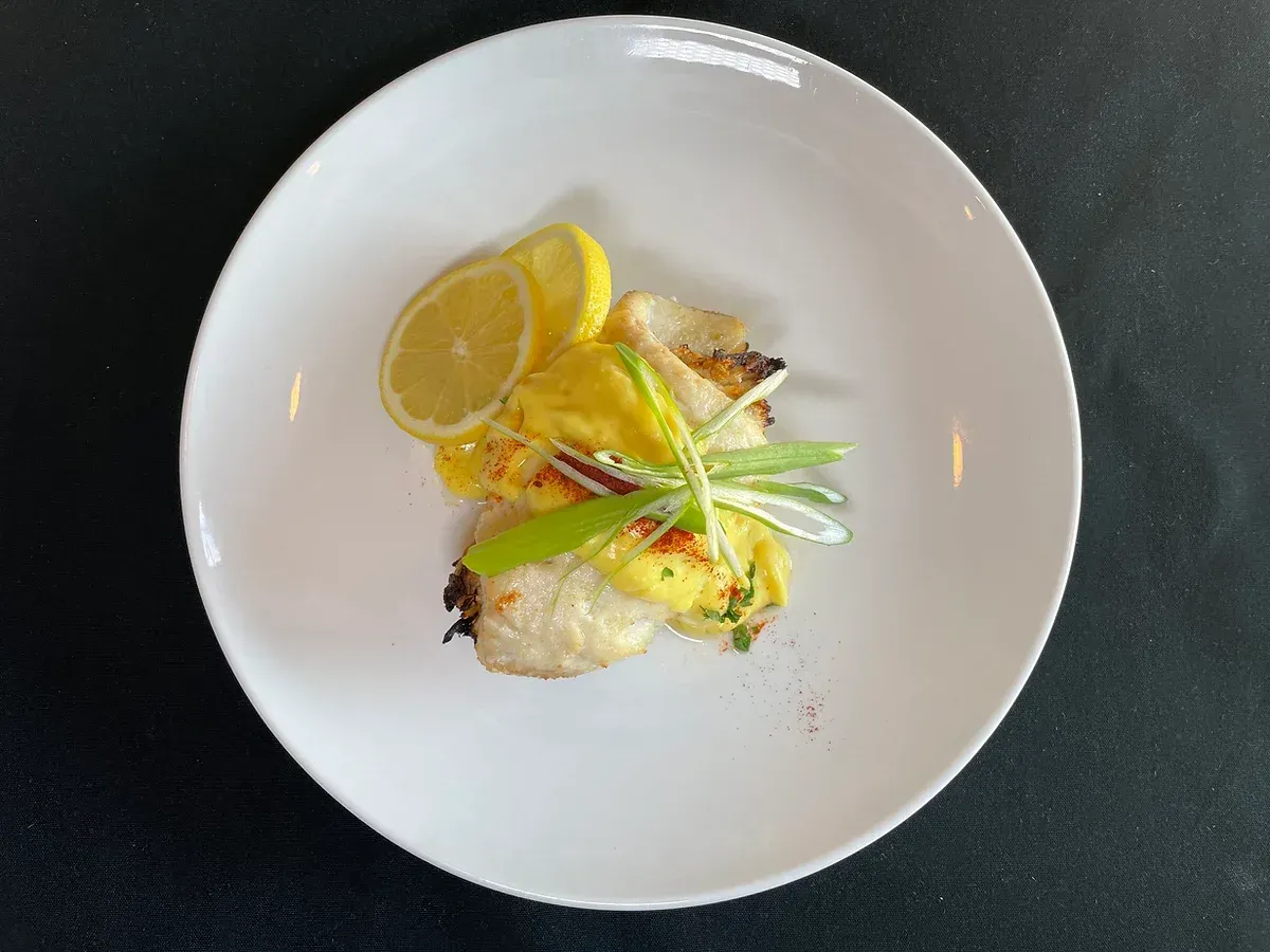 A white plate topped with food and lemon slices