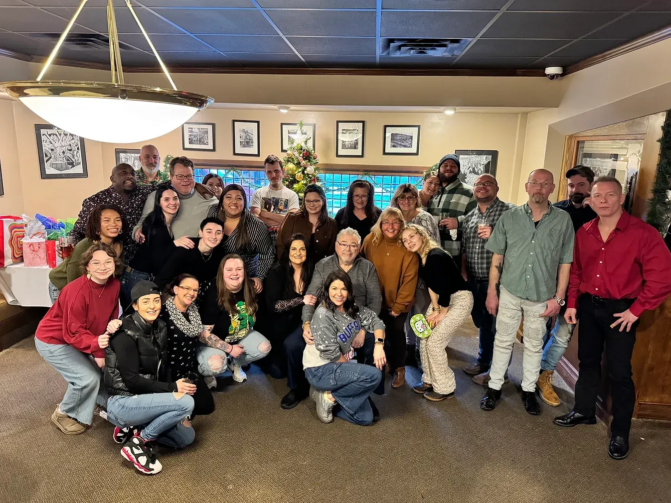 A large group of people are posing for a picture in a room.