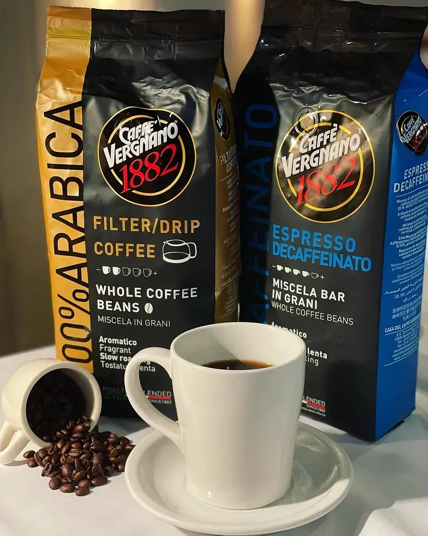 A cup of coffee next to a bag of coffee beans