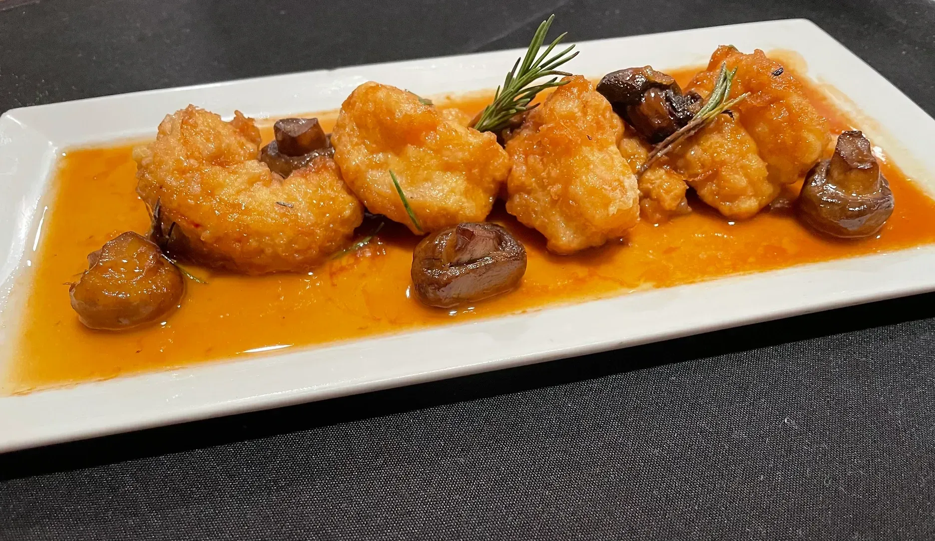 A plate of food with shrimp and mushrooms on a table