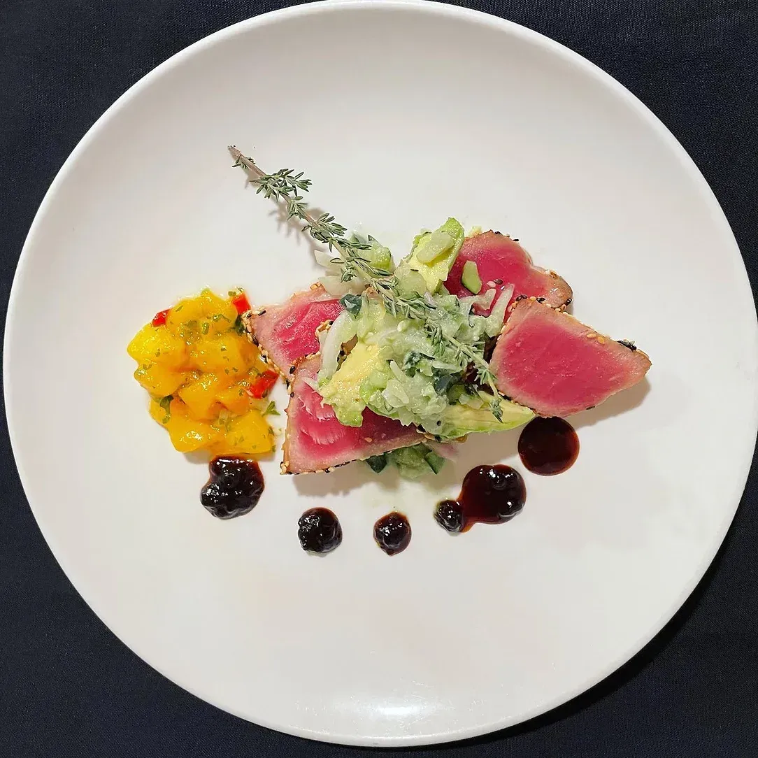 A white plate topped with meat and vegetables on a table