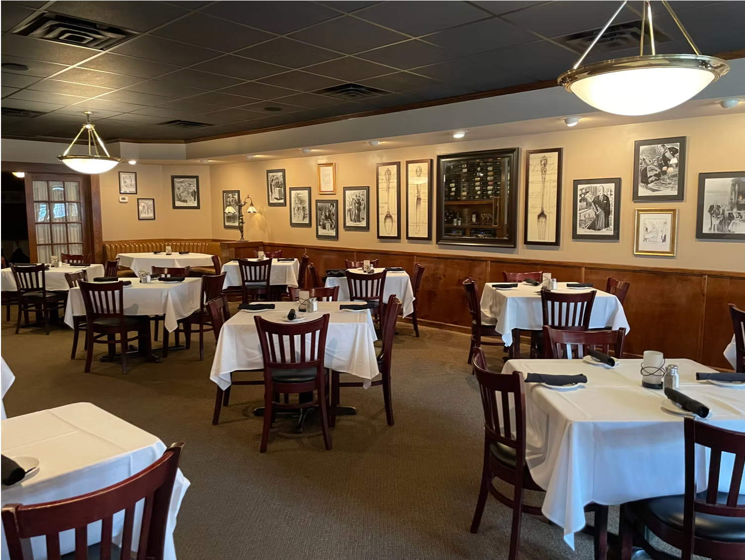 A restaurant with tables and chairs and pictures on the wall