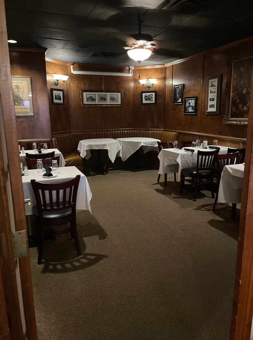 A restaurant with tables and chairs and a ceiling fan