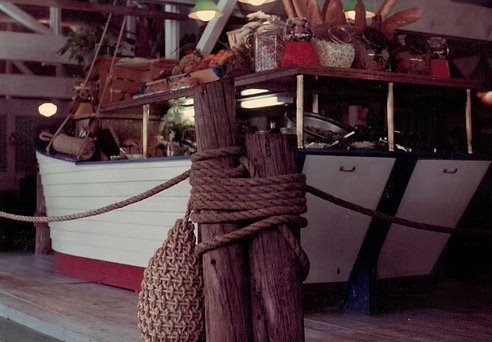 A wooden post with a rope around it in front of a boat