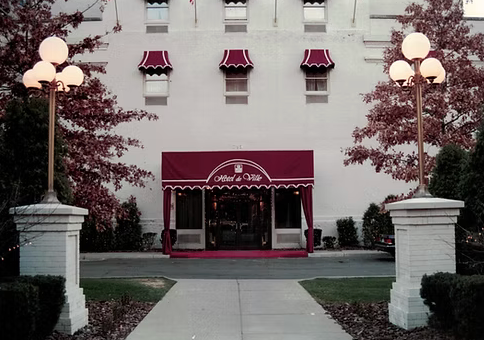 A white building with a red awning on the front