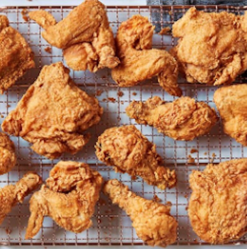 A bunch of fried chicken on a cooling rack