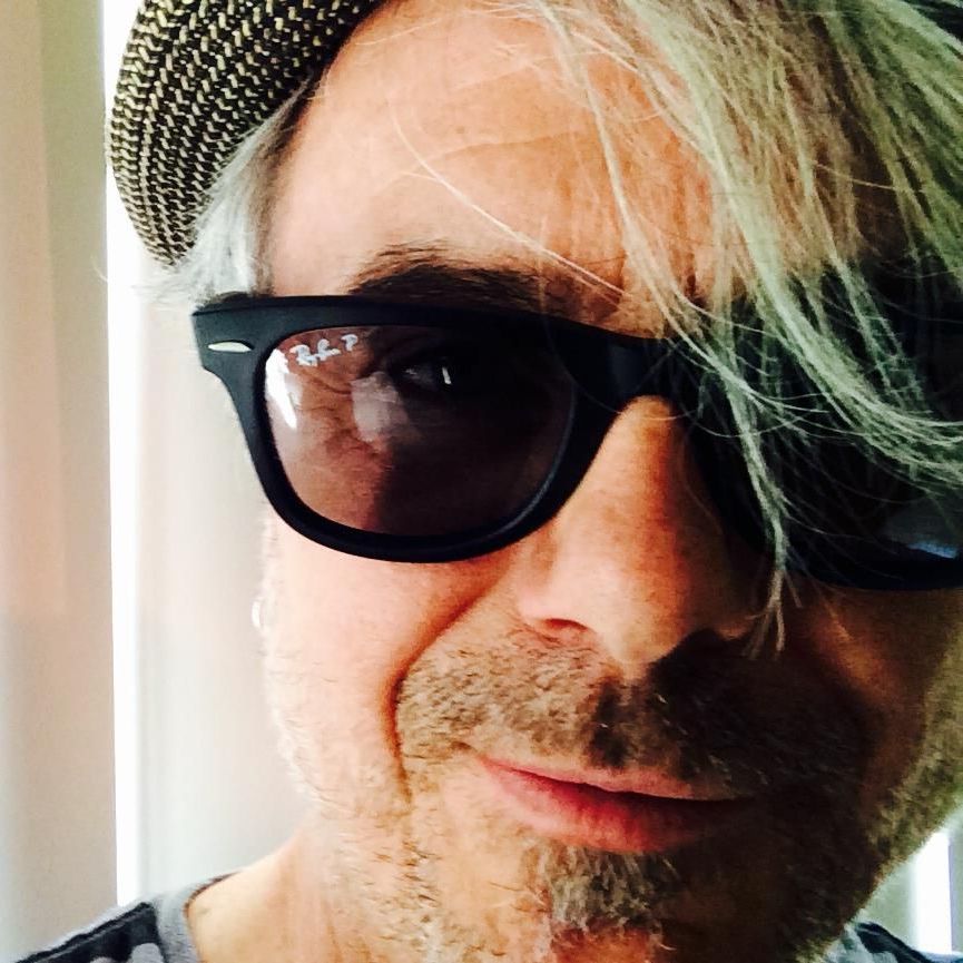 a man in a black jacket is playing an electric guitar