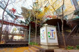 City Museum sign in front of a whimsical building with metal structures, bridges, and a tree.