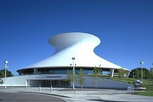 White, mushroom-shaped building with a circular base, under a clear blue sky.