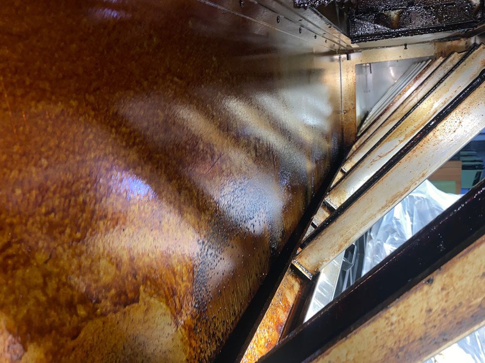 Greasy interior of a metal industrial ventilation system.