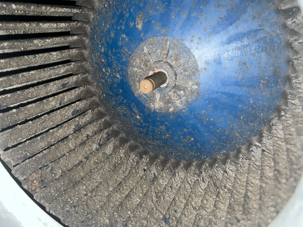 Blue and gray abrasive flap disc with central metal shaft, worn appearance.