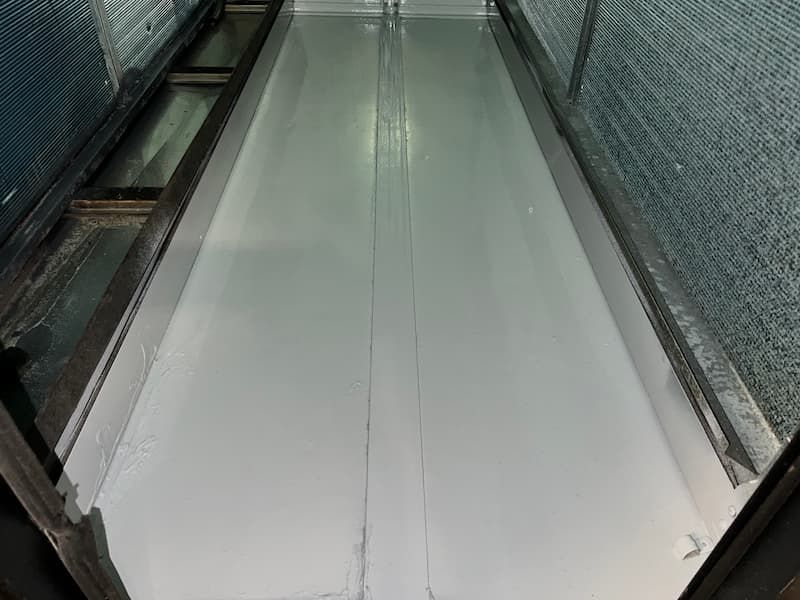 A long, light grey industrial trough with a center seam, viewed from above.