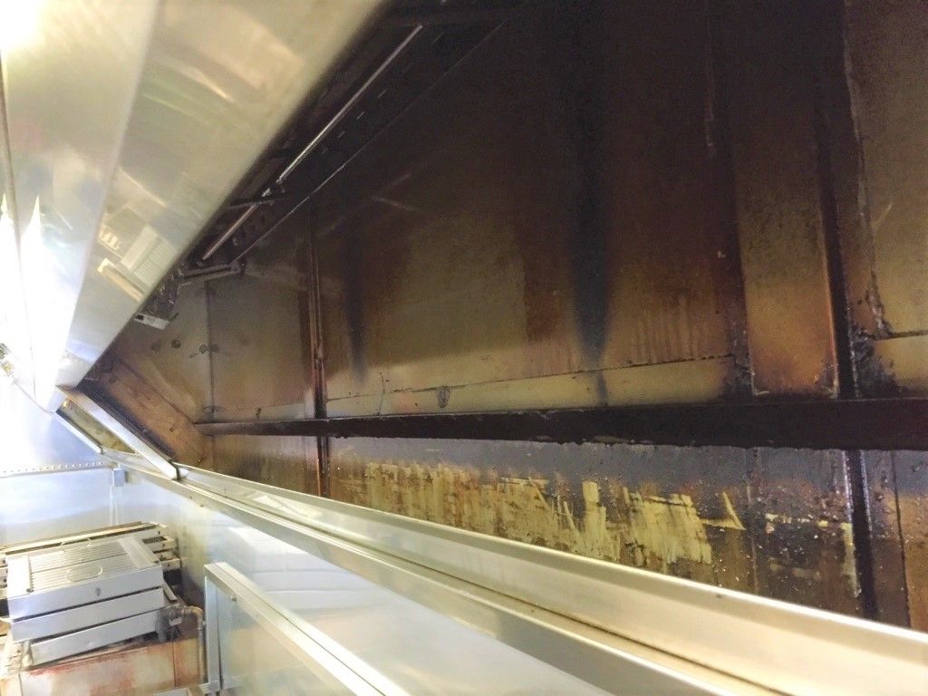 Greasy, darkened commercial kitchen hood interior.