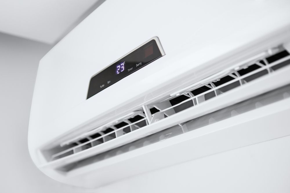 White wall-mounted air conditioner unit with digital display showing 25 degrees.