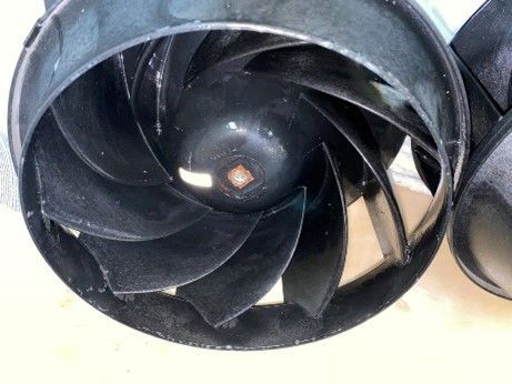 Black jet impeller with curved blades inside a dark housing.