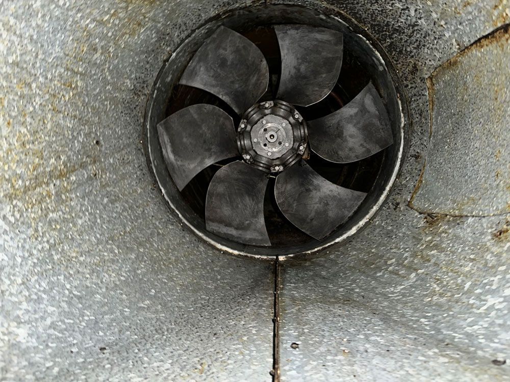 Ceiling fan with five blades inside a metal duct.
