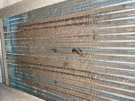 Dirty air conditioning coil covered in dust and debris.