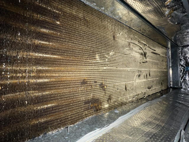 Dirty air conditioning evaporator coil inside a metal housing.