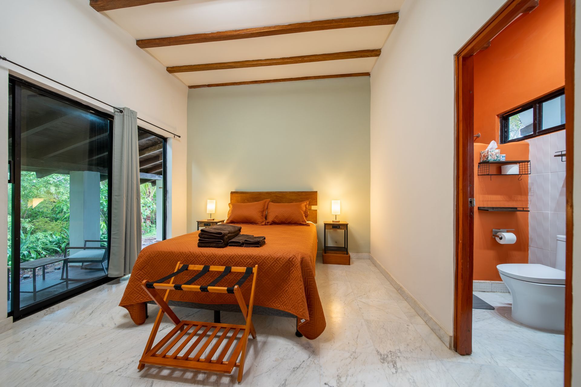 A bedroom with a large bed and a toilet