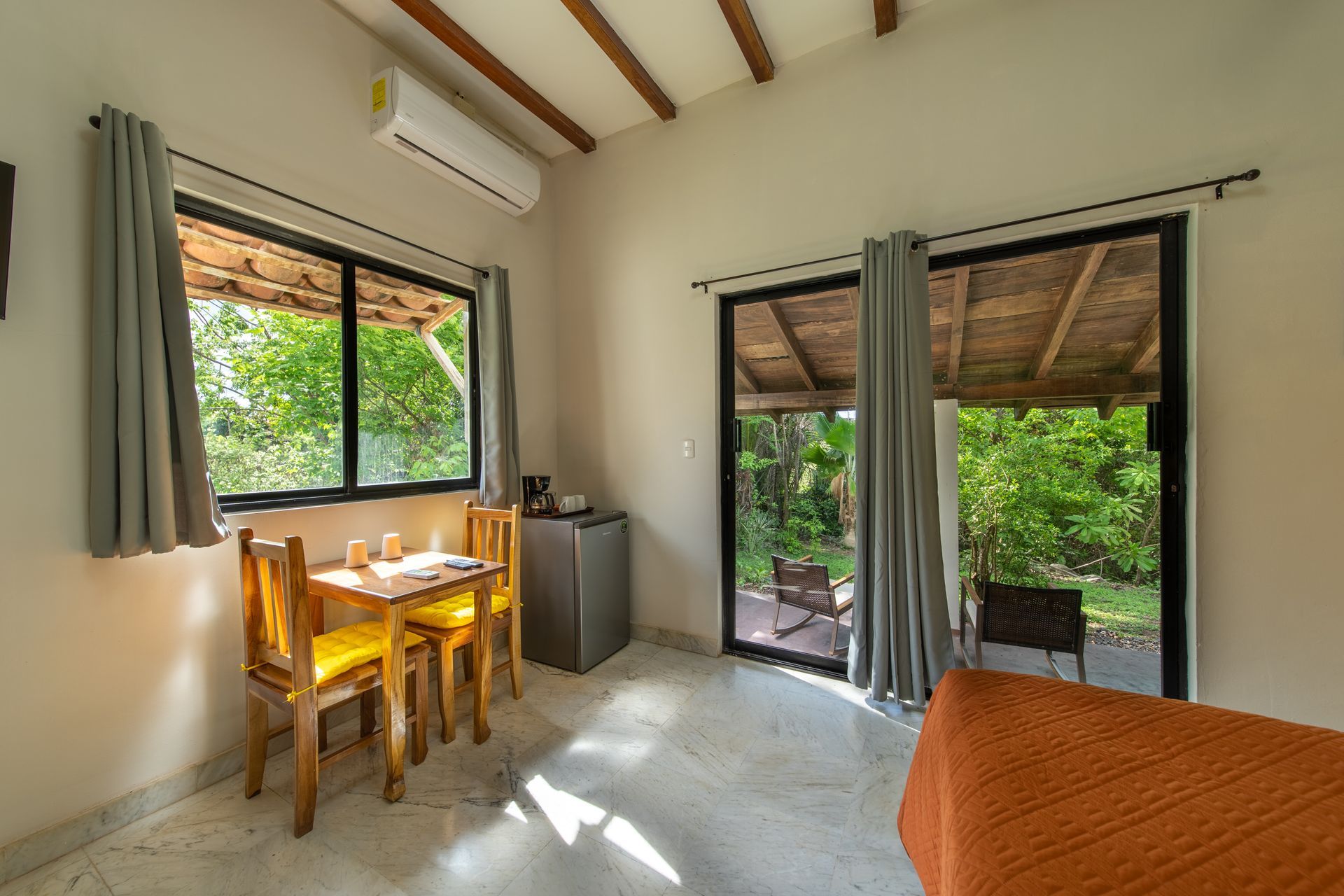 There is a table and chairs in the room with a sliding glass door.