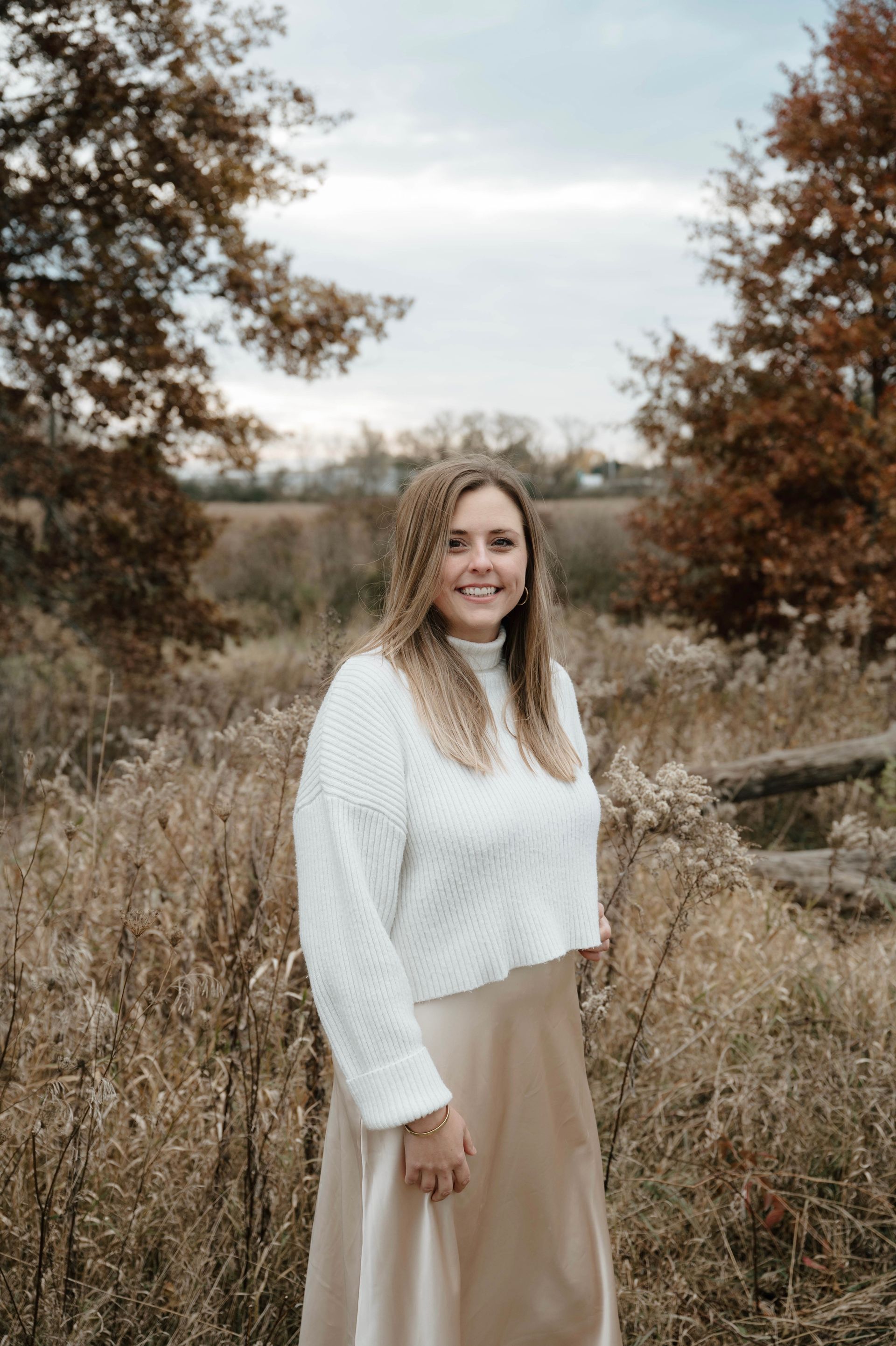 A man in a suit and tie is standing next to a wall.
