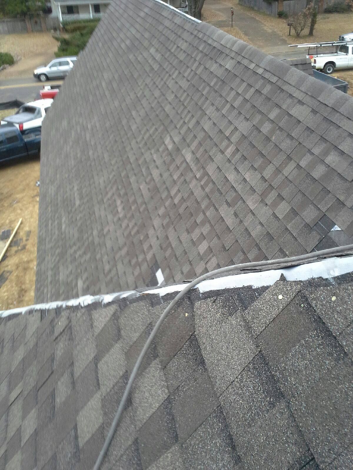 Gray asphalt shingle roof with some debris; residential setting.