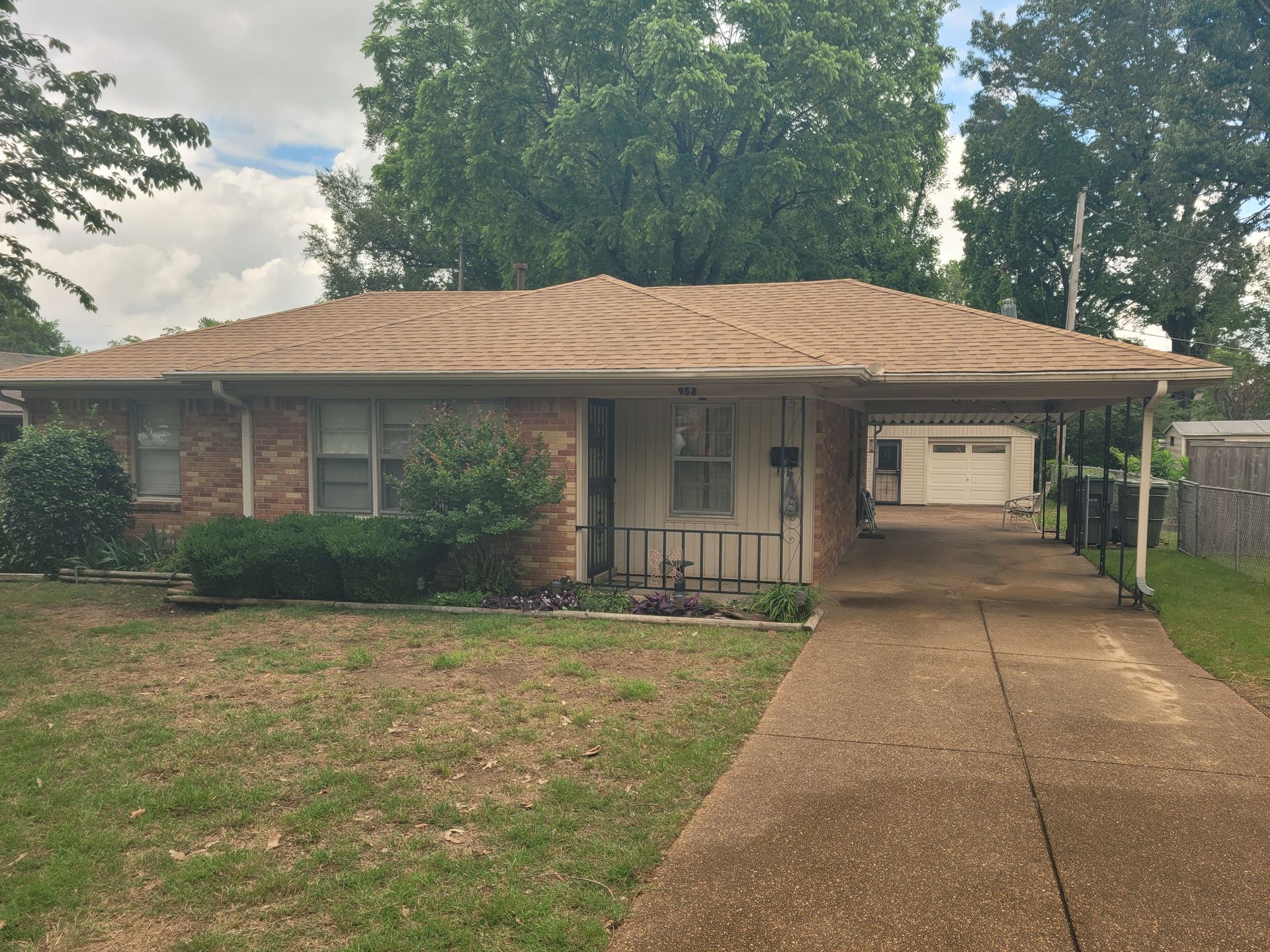 White two-story house under construction with dark roof and blue sky background.