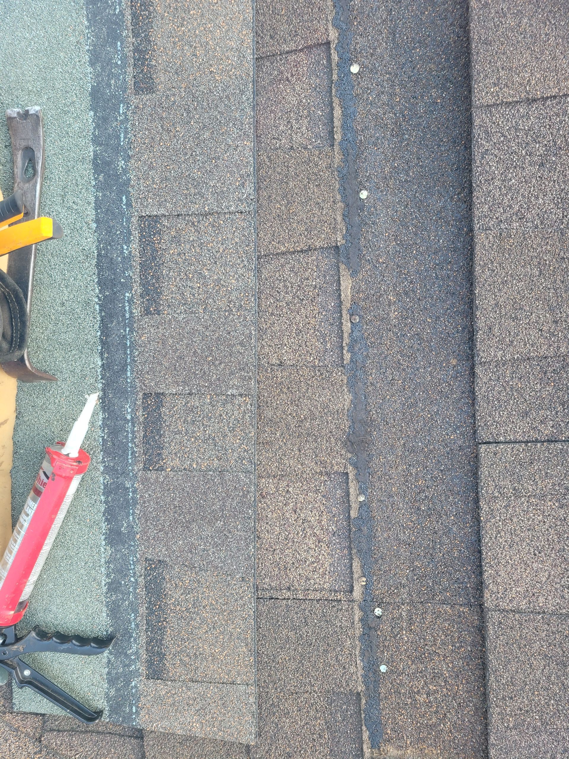 Brick building with two garage doors, windows, and a parked van. A person works near the van.