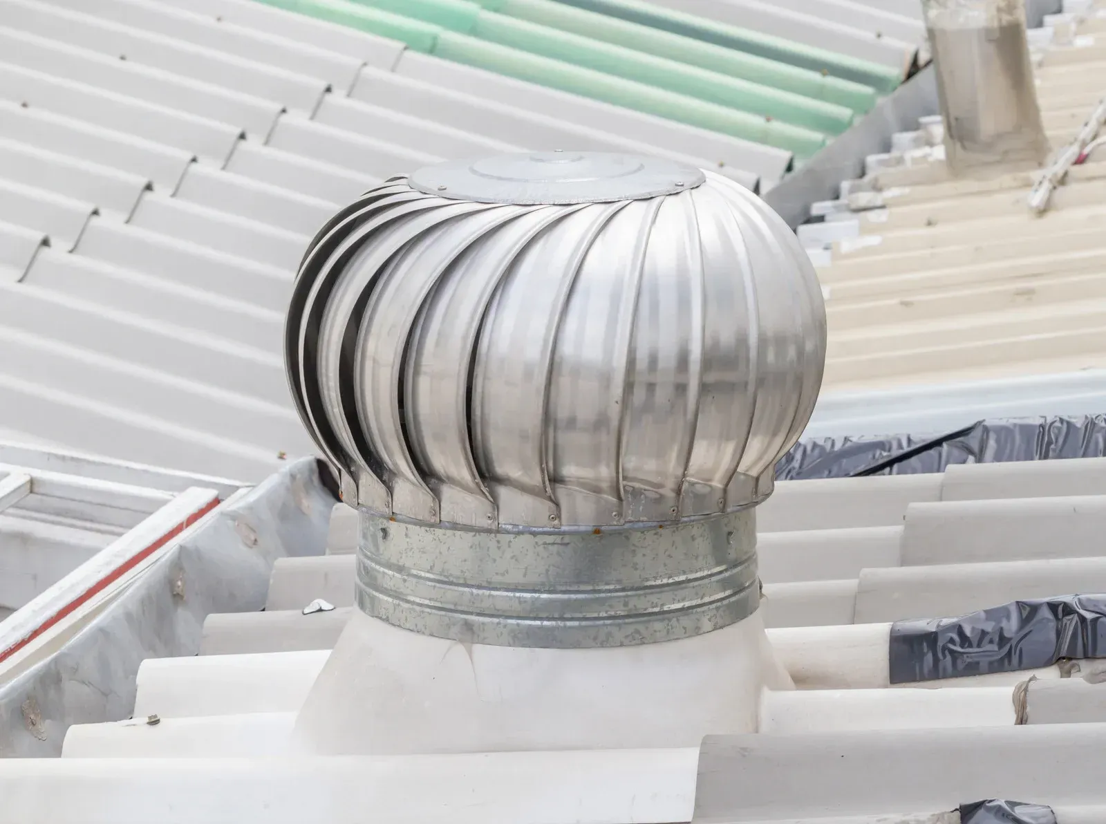 Metal roof turbine vent on white roof, spiraling design.