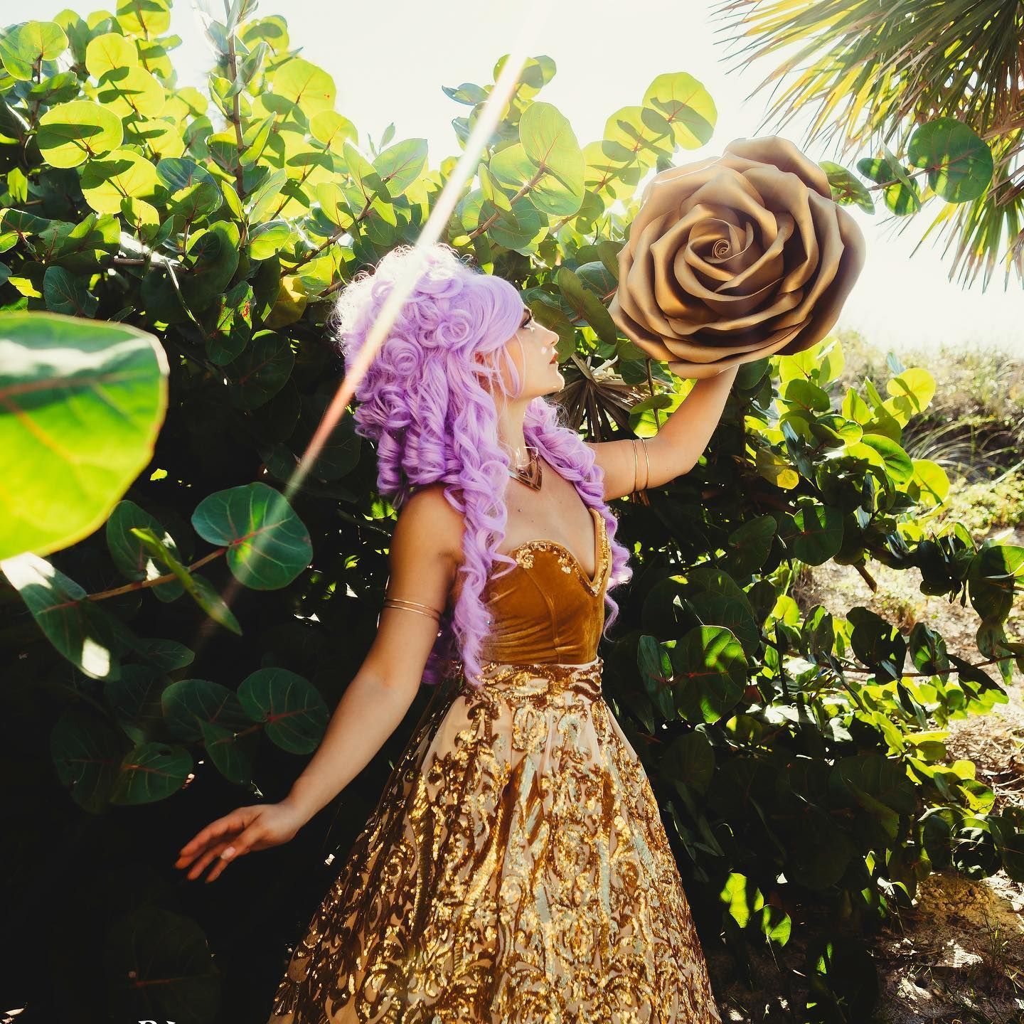 a woman in a purple wig is holding a large rose in her hand
