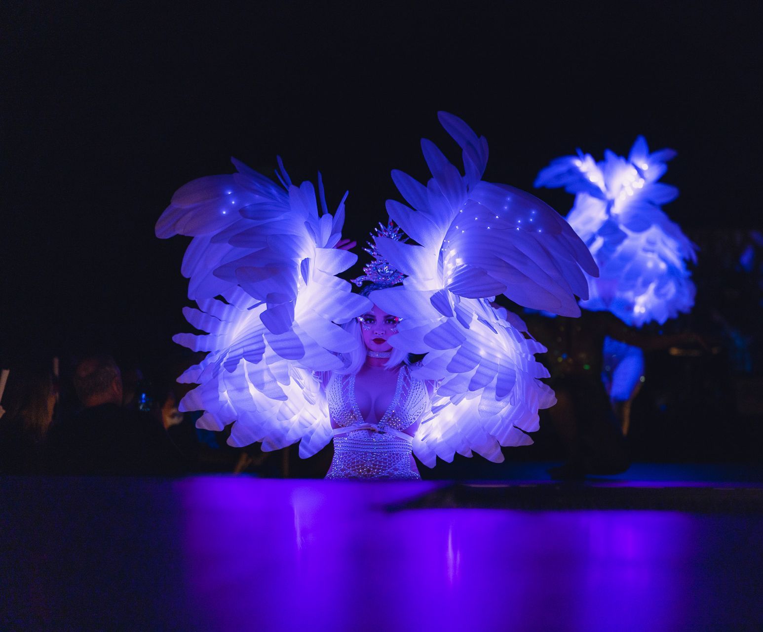 A woman is wearing a costume with wings that are glowing in the dark.
