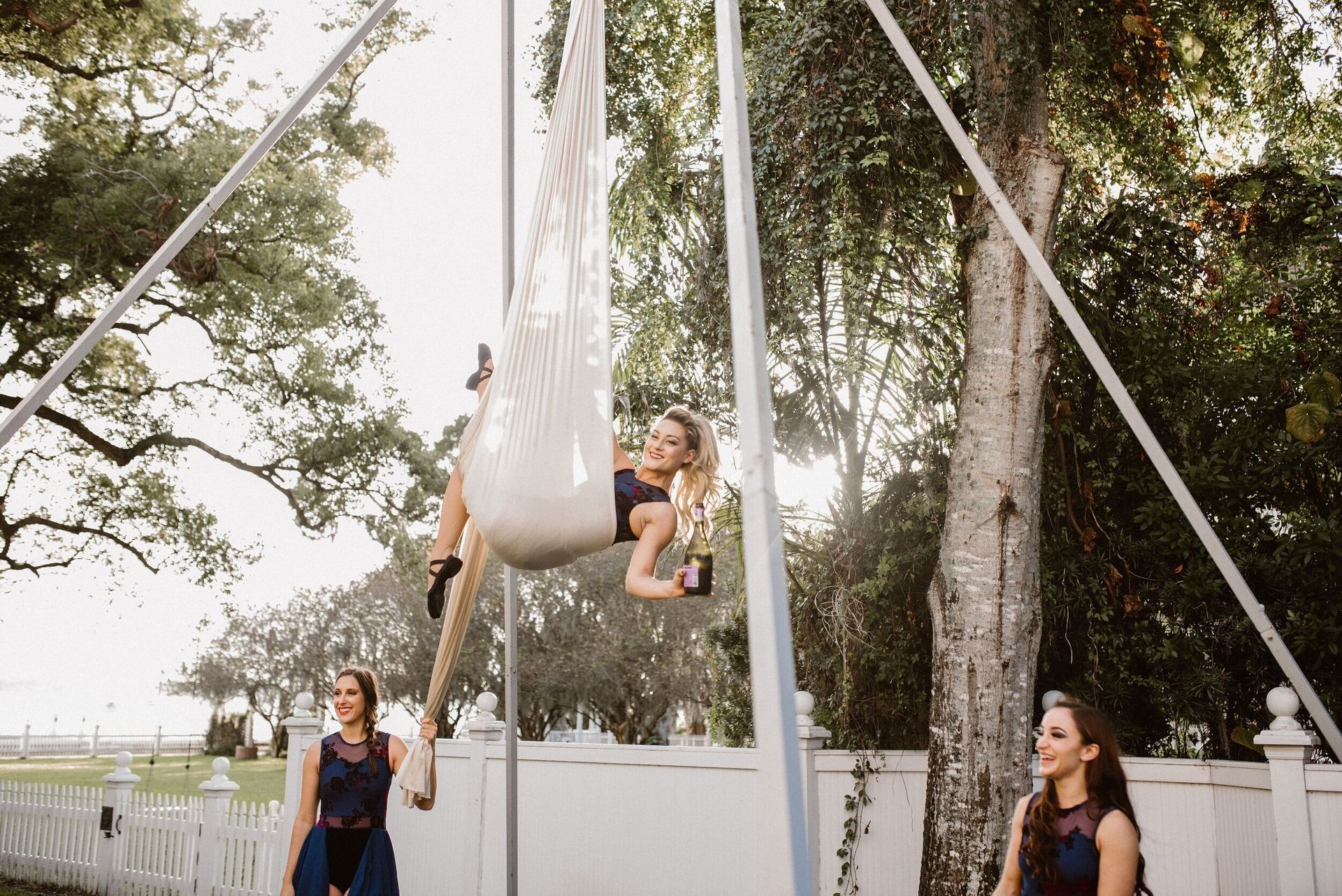 a woman is doing aerial yoga in a hammock with a bottle