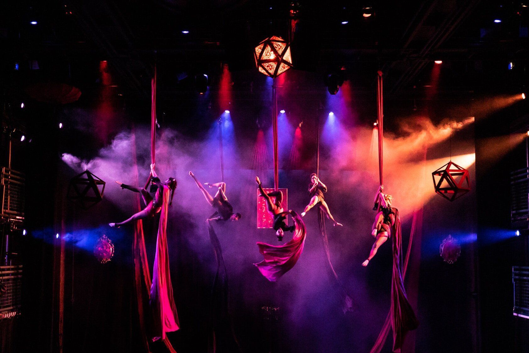 A group of people are performing aerial acrobatics on a stage.