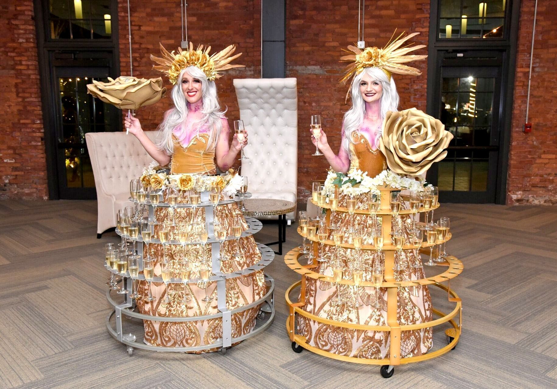 A woman in a green dress is holding a glass of champagne.