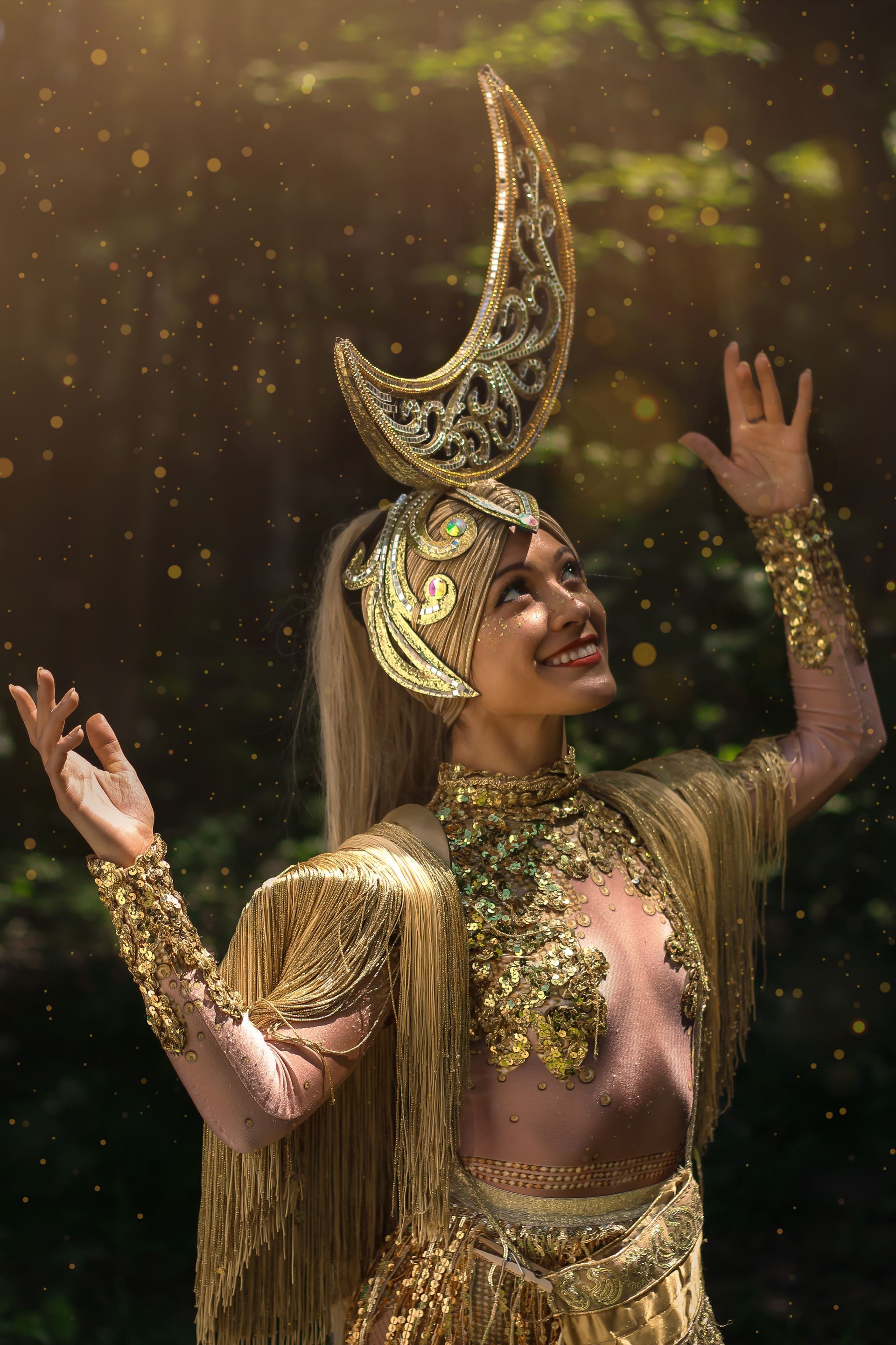 a woman in a gold costume with a crescent moon on her head .