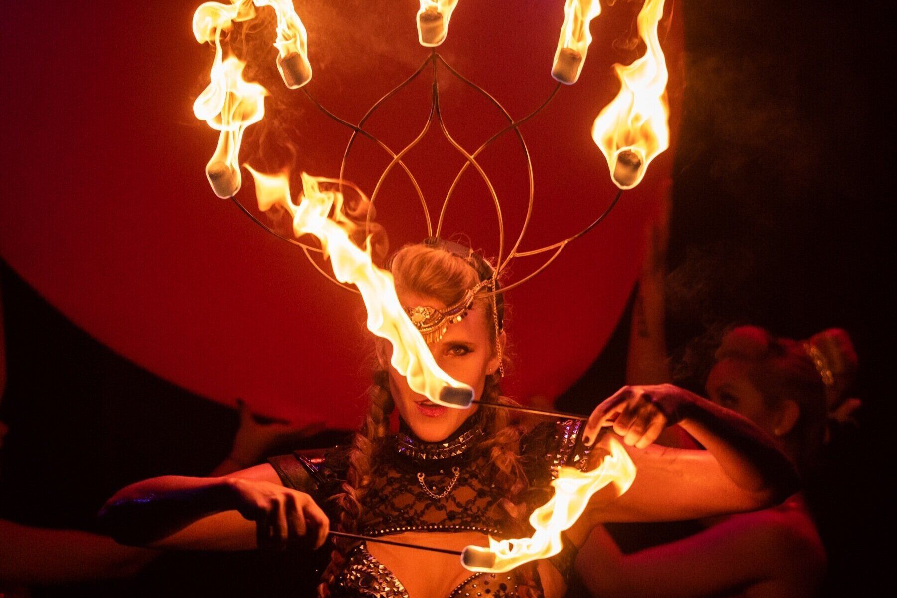 A woman is holding fire sticks in her hands.