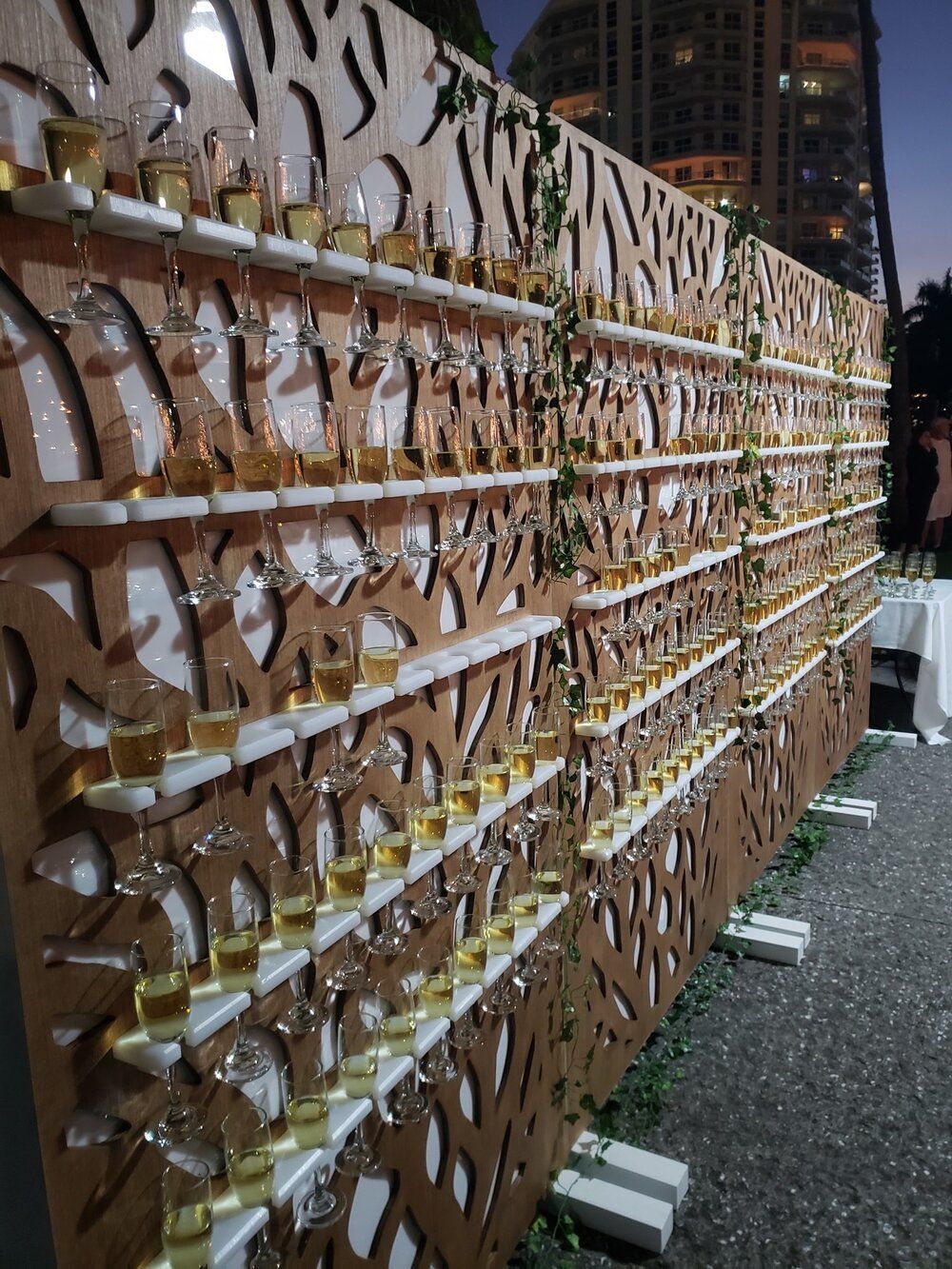 A wall filled with lots of champagne glasses on shelves.