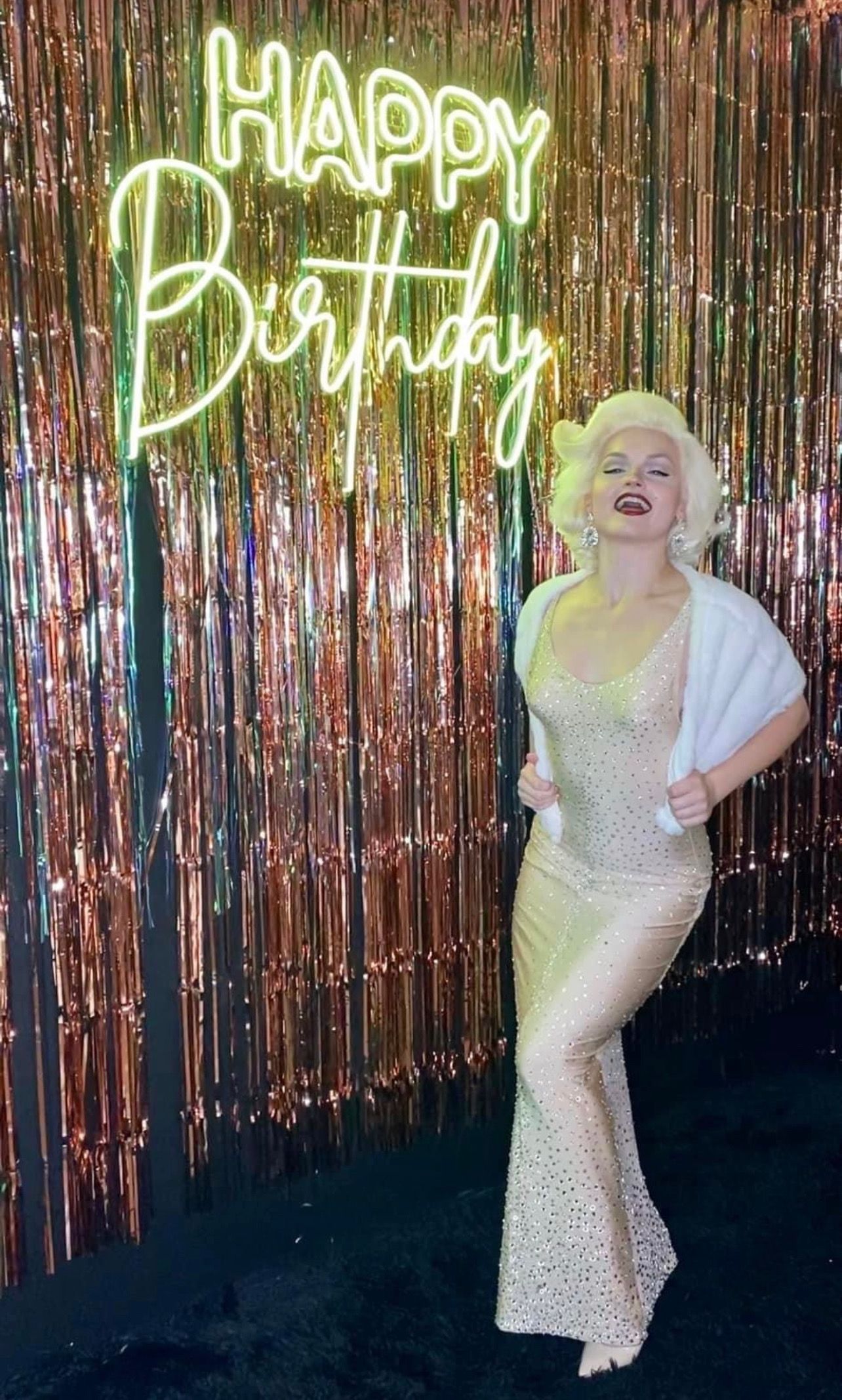 A group of dancers are posing for a picture while holding fans and umbrellas.