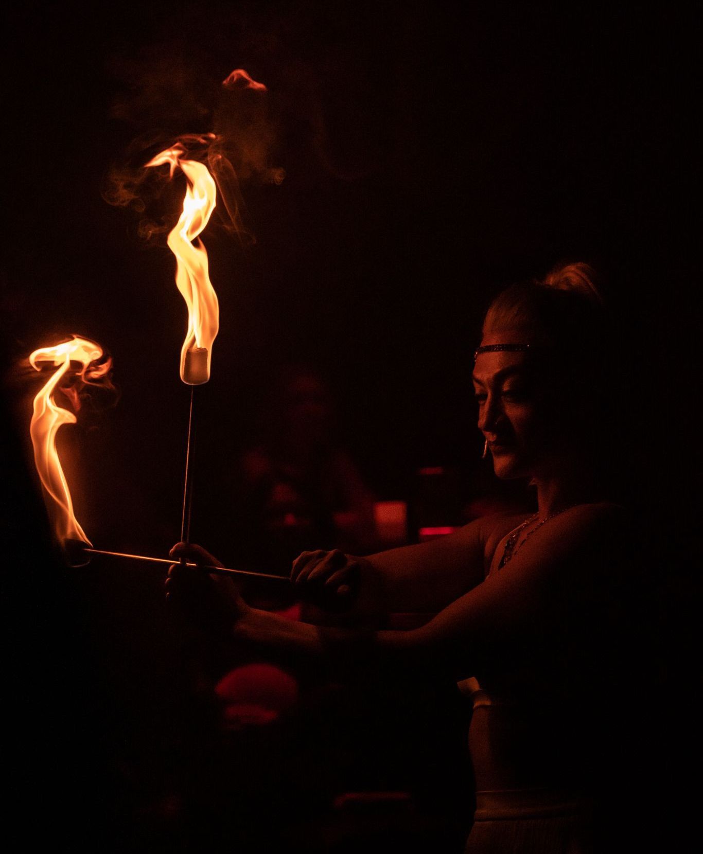 A woman is holding a torch in her hand in the dark.