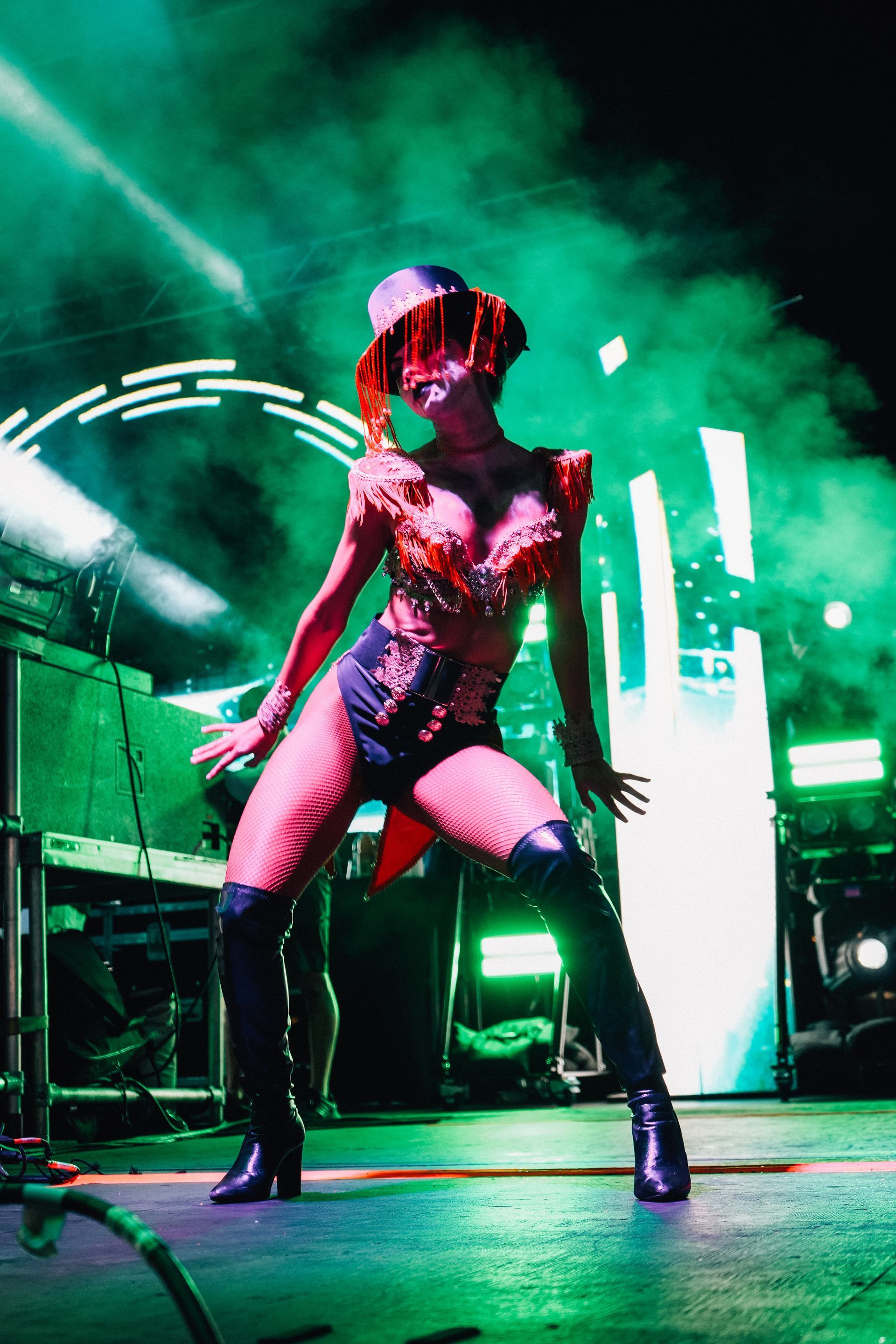A group of women are dancing on a stage in a dark room.