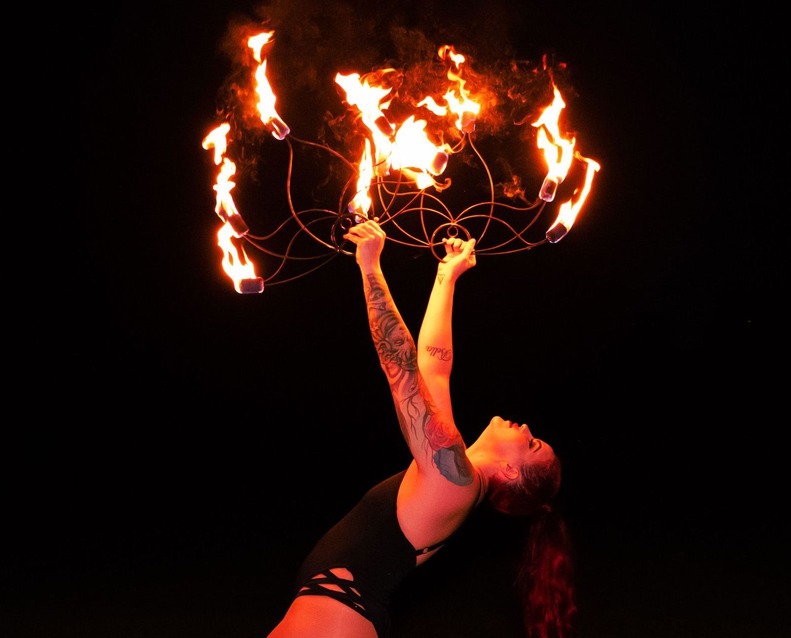A woman is holding an ornament of fire in her hands.