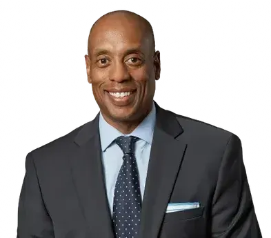 A man in a suit and tie is smiling for the camera.