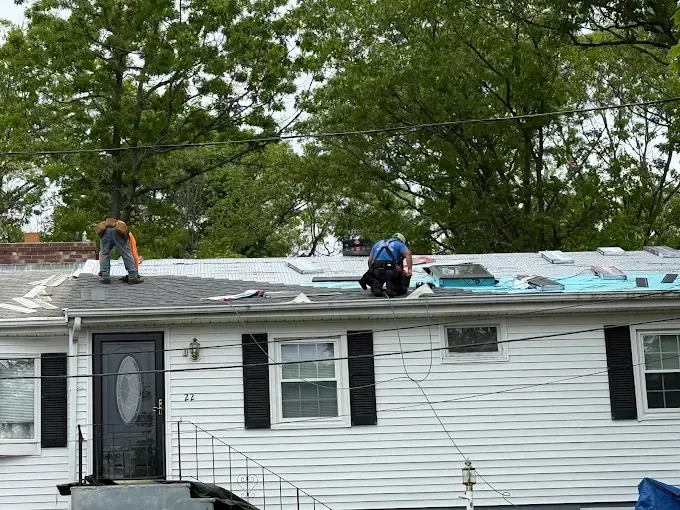 A couple of men are working on the roof of a house.