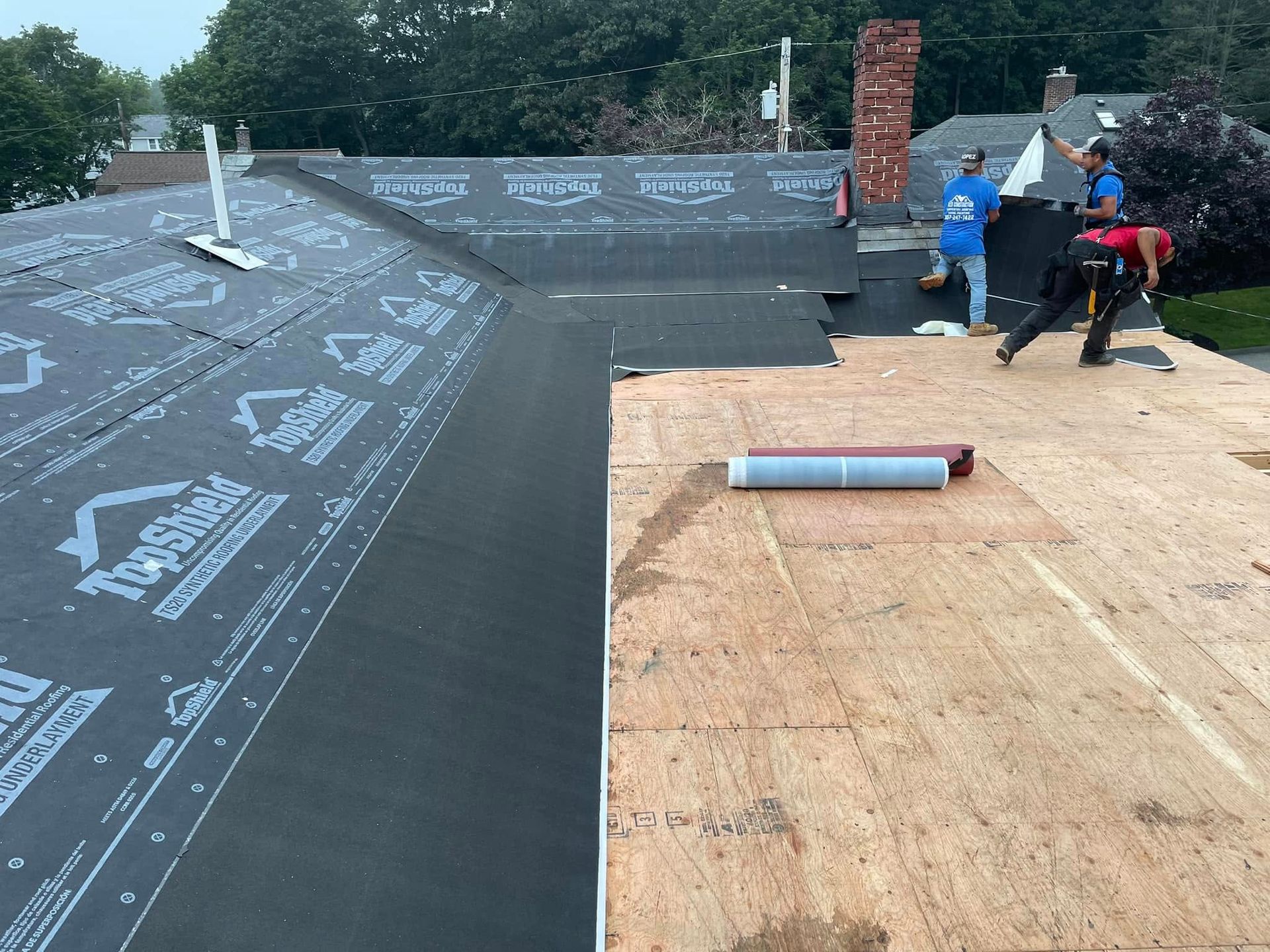 A group of people are working on a roof.