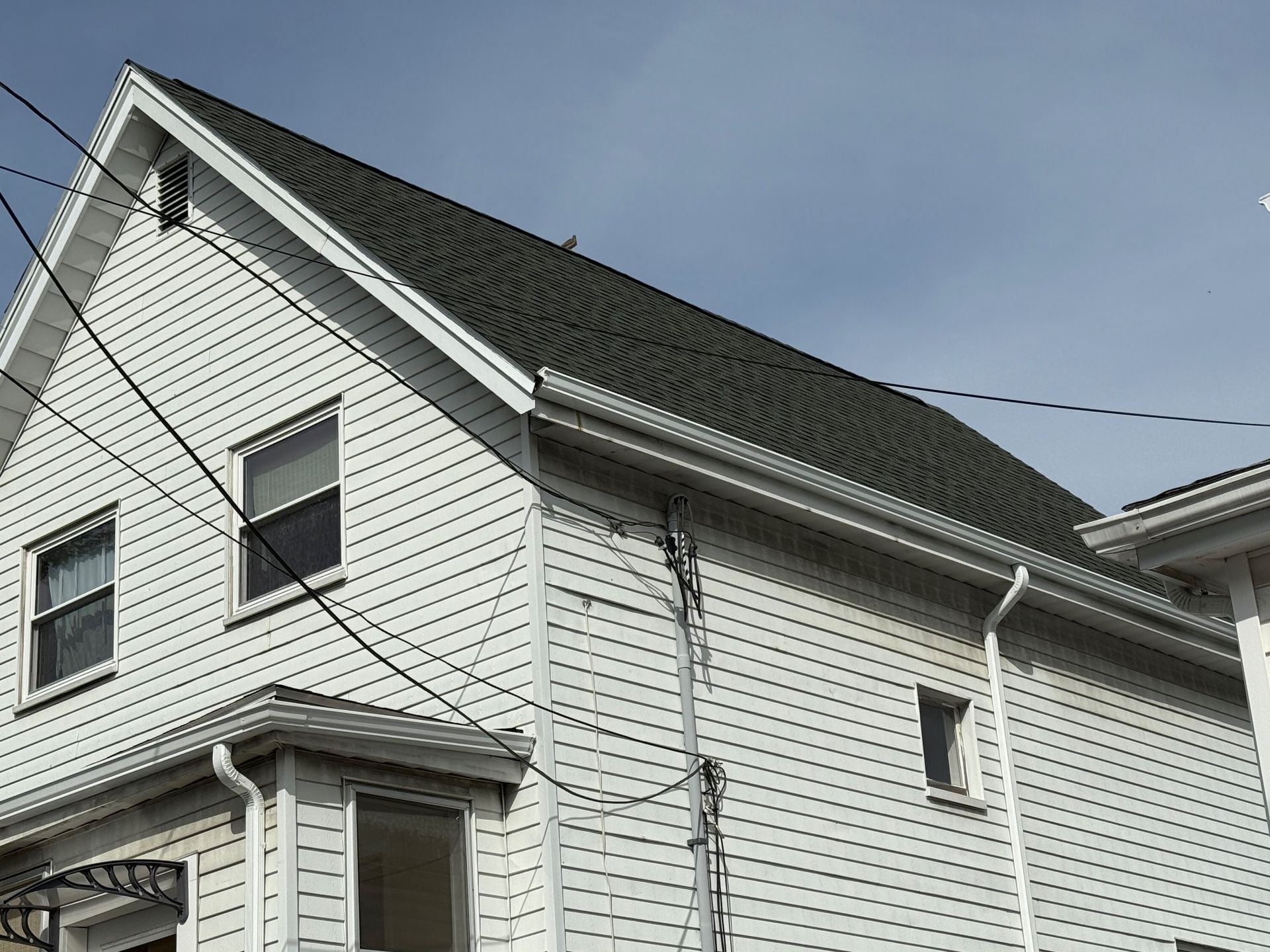 A white house with a black roof and windows