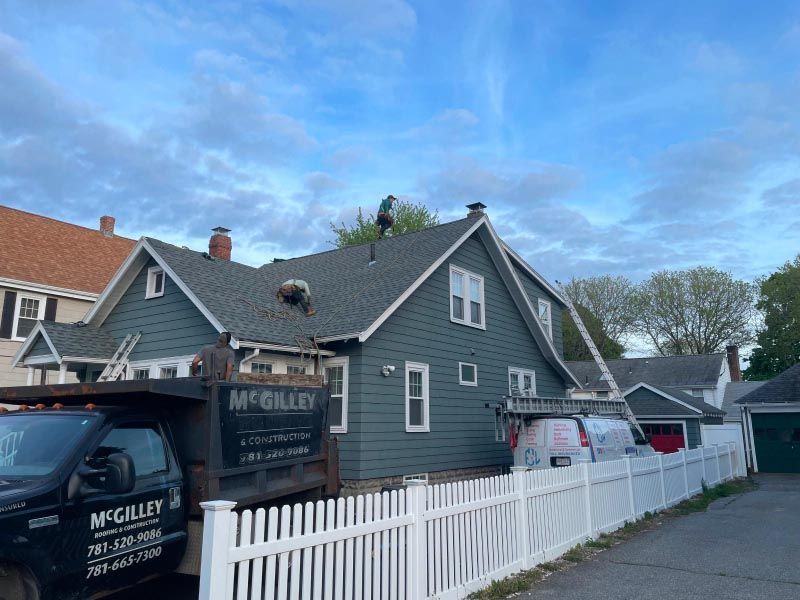 A truck is parked in front of a house with a white picket fence.